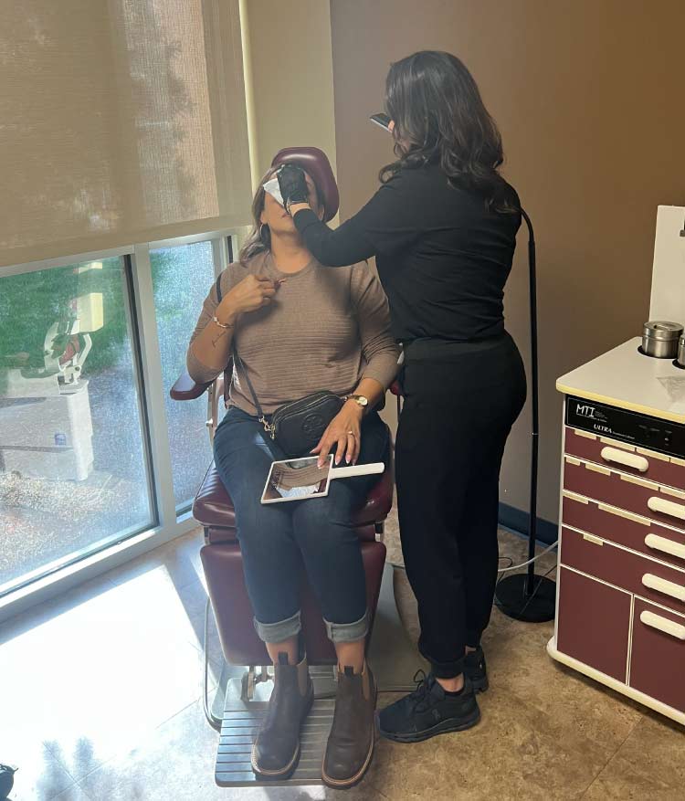 Registered Nurse performing a wrinkle relaxer injection treatment for a patient at Le Vestige Aesthetics medical spa in Hanford, CA to reduce forehead lines and crow's feet.